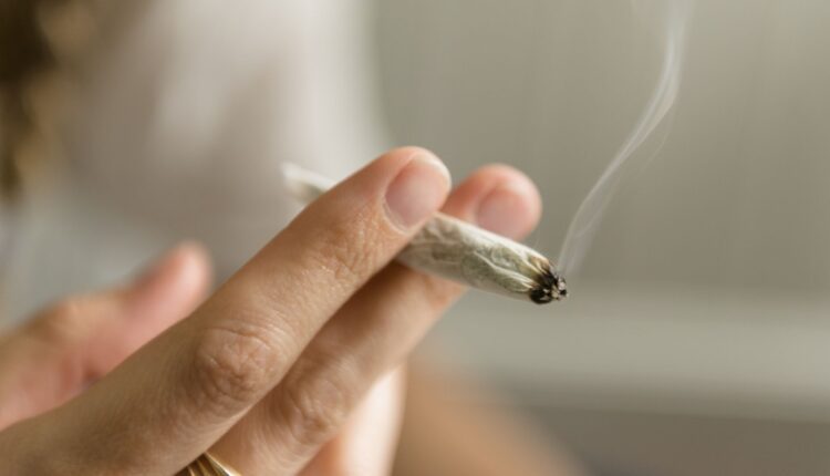 Hand of woman smoking marijuana joint