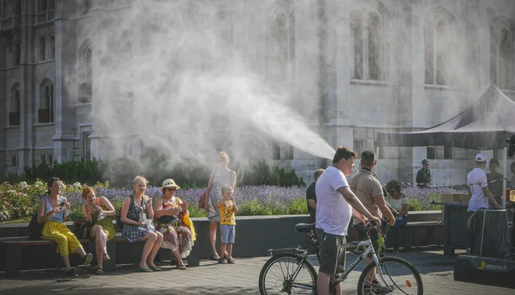 People cooling off from mist spray on a hot day