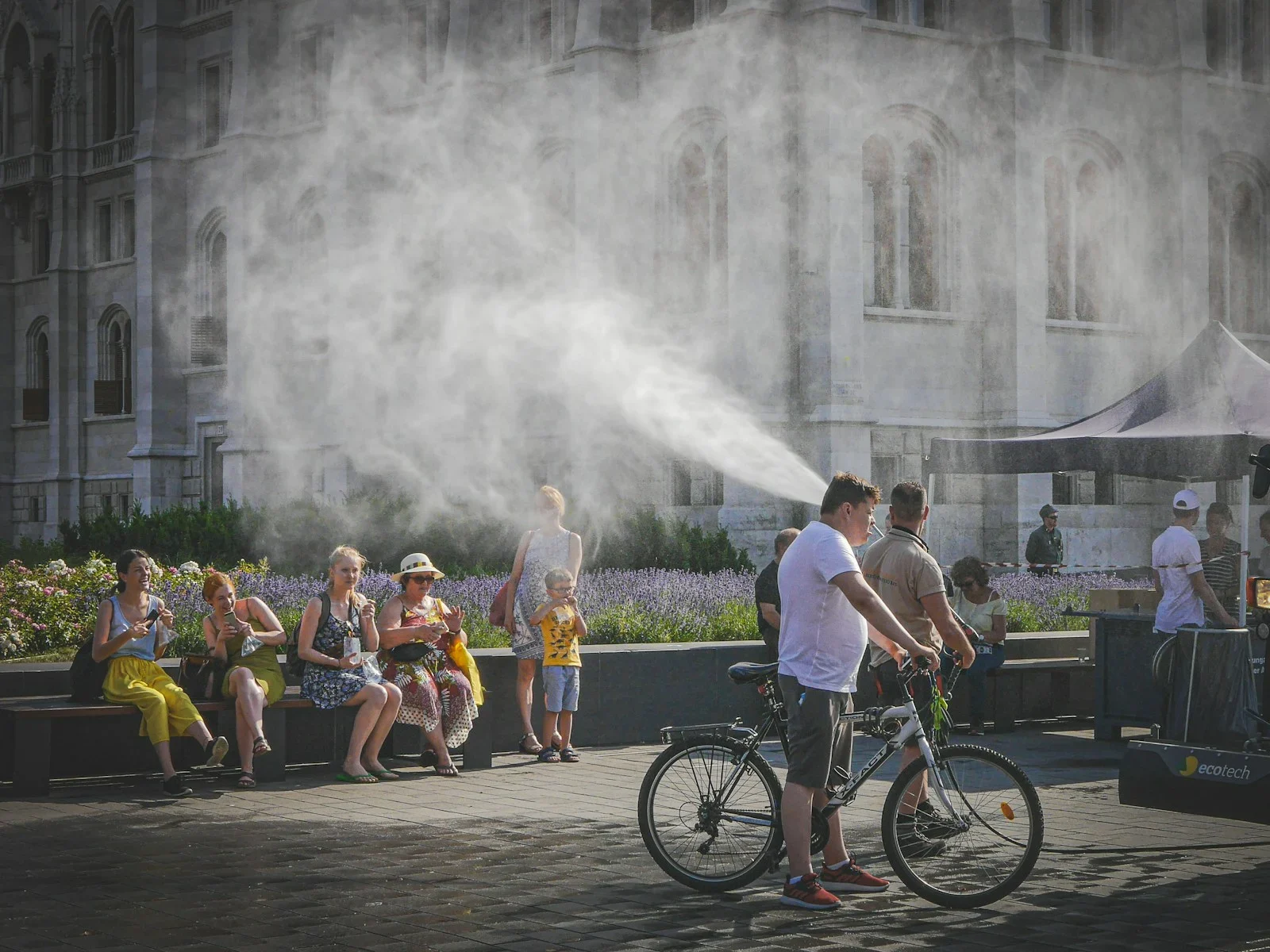People cooling off from mist spray on a hot day