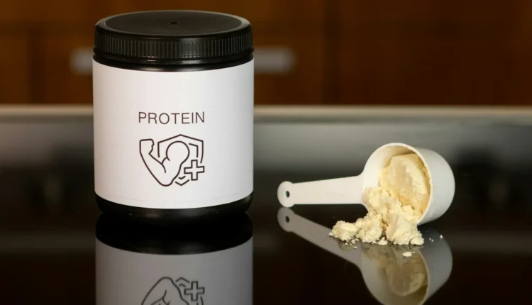 a container of protein powder next to a spoon