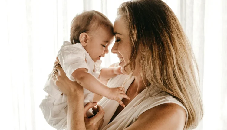 smiling woman carrying baby