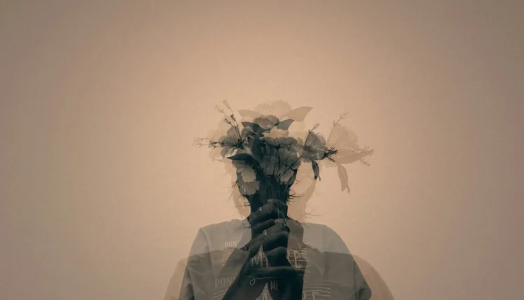 gray scale photo of man holding flower